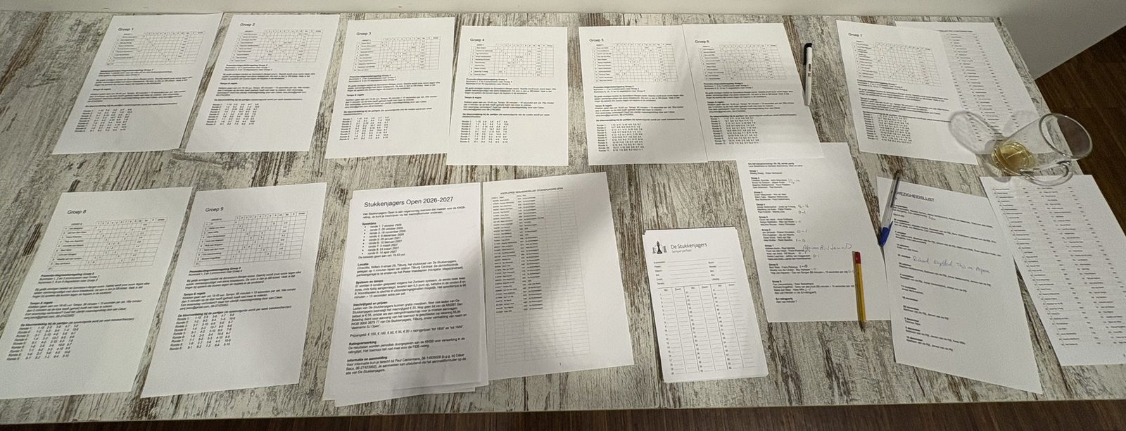 The table by the door: printed group standings, the latest SJ rating list, blank scoresheets.